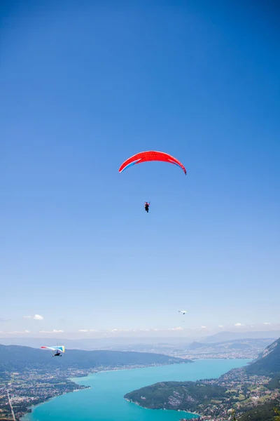 Planeador colgante y parapente volando sobre el lago Annecy a través del monte —  Fotos de Stock