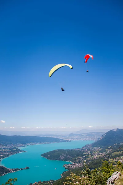 Parapentes Volando sobre el lago Annecy y el paisaje de montaña en Bl —  Fotos de Stock