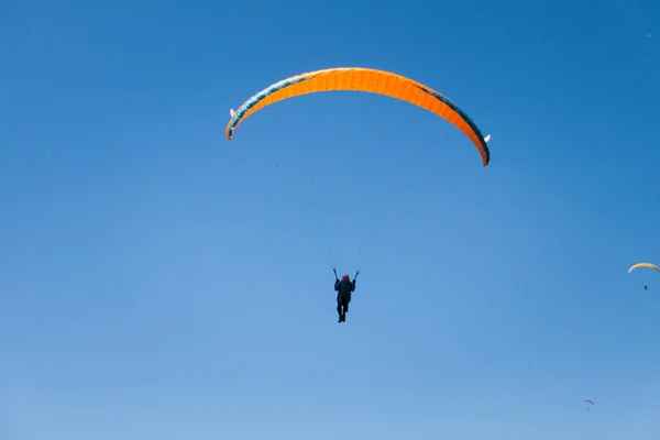 Turuncu Yelken Ile Mavi Gökyüzünde Uçan Yamaç Paraşütü — Stok fotoğraf