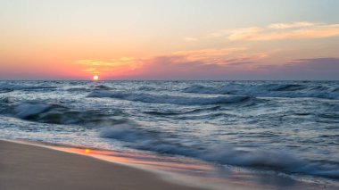 Bir sıcak, yaz akşam kaba dalgalar ile denizde güzel gün batımı.