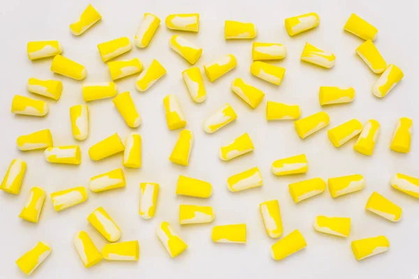 A lot of lying earplugs, for protection against noise in yellow and white, isolated on a white background with a clipping path.