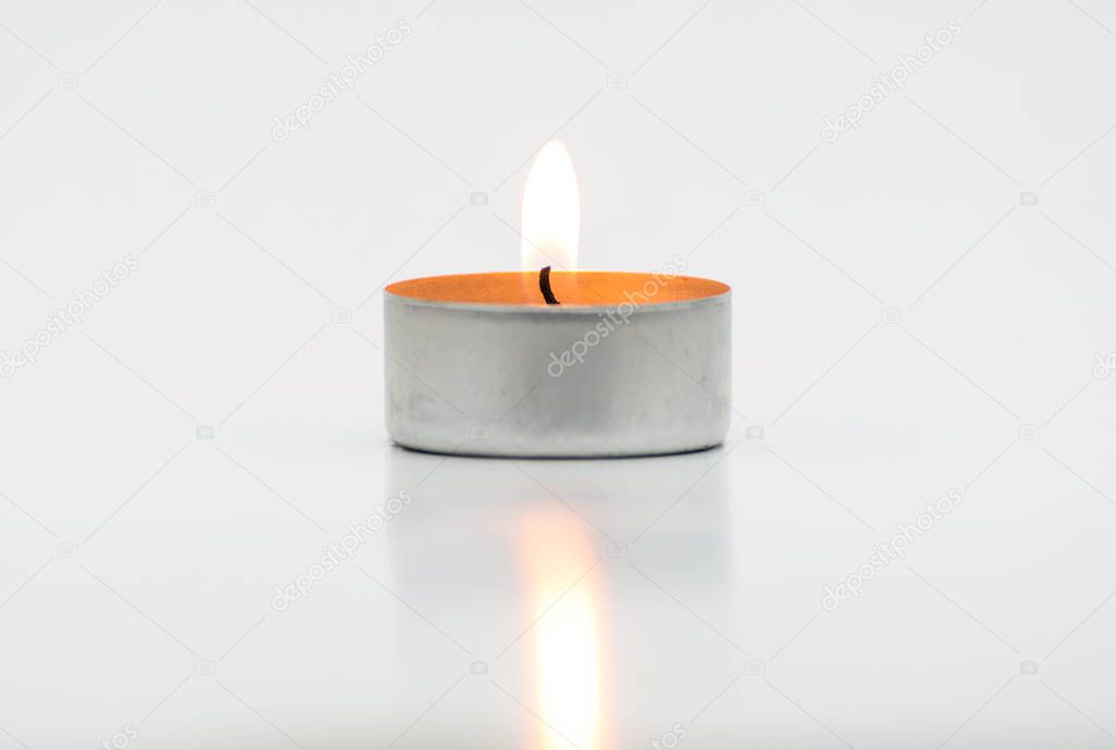 Burning paraffin candles, tealight, lies on a white background with a clipping path.