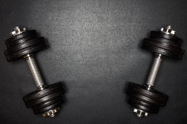 Gym dumbbells on black background with copy sapce, Photograph taken from above.