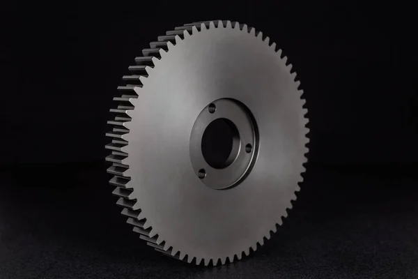 Plastic, black gear with 68 sprockets, isolated on a black background.