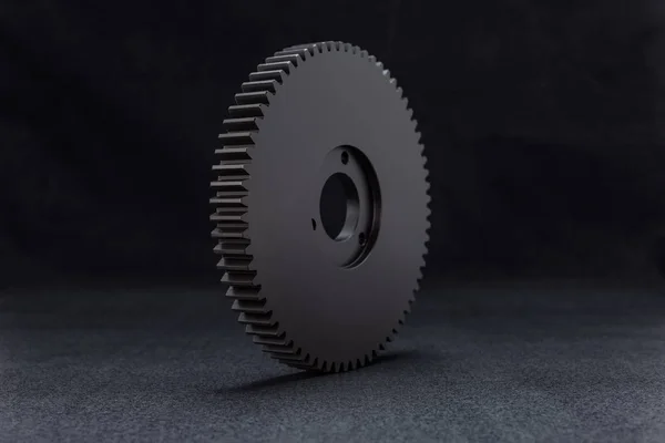 Plastic, black gear with 68 sprockets, isolated on a black background.