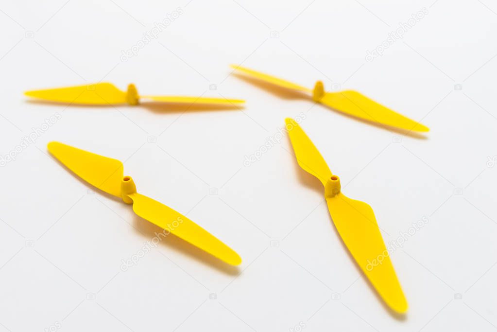 Yellow, plastic propellers for a quadcopter drone, isolated on white background. 