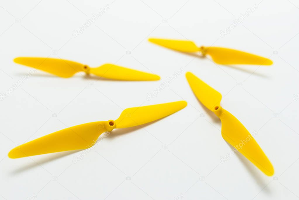 Yellow, plastic propellers for a quadcopter drone, isolated on white background. 