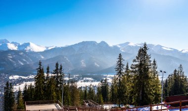 Polonya Tatra Dağları'nın eteklerinde yalan Zakopane şehir güzel bir manzara. Güneşli, güzel bir gün kış, karla kaplı dağlar görünür ağaçlar ve Binalar.