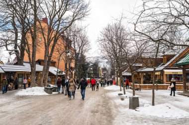 Zakopane, Polonya - 22 Şubat 2019. Kişilik bir kalabalık Krupowki cadde boyunca bir kış gününde yürüyor. Krupowki, şehrin ana promenade Zakopane sokaktır. Sokağın Hediyelik eşya dükkanları ile dolu.