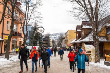 Zakopane, Polonya - 22 Şubat 2019. Kişilik bir kalabalık Krupowki cadde boyunca bir kış gününde yürüyor. Krupowki, şehrin ana promenade Zakopane sokaktır. Sokağın Hediyelik eşya dükkanları ile dolu.