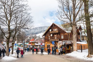 Zakopane, Polonya - 22 Şubat 2019. Kişilik bir kalabalık Krupowki cadde boyunca bir kış gününde yürüyor. Krupowki, şehrin ana promenade Zakopane sokaktır. Sokağın Hediyelik eşya dükkanları ile dolu.