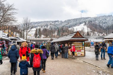 Zakopane, Polonya - 22 Şubat 2019. Kişilik bir kalabalık Krupowki cadde boyunca bir kış gününde yürüyor. Krupowki, şehrin ana promenade Zakopane sokaktır. Sokağın Hediyelik eşya dükkanları ile dolu.