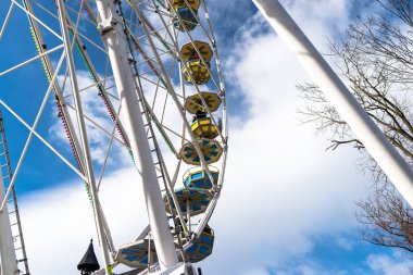 Dönme dolap ile beyaz bulutlar ile güzel bir mavi gökyüzü karşı bir lunapark içinde renkli gondol.