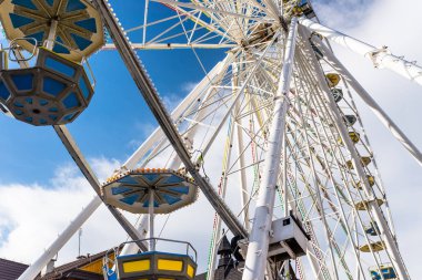Dönme dolap ile beyaz bulutlar ile güzel bir mavi gökyüzü karşı bir lunapark içinde renkli gondol.