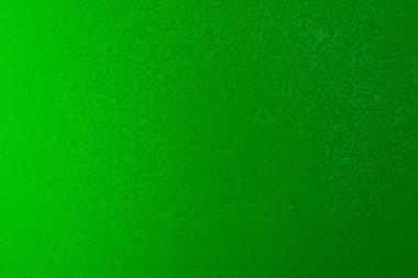 Küçük hassas bir ışıkla aydınlatılmış yeşil, mat bir arka plan üzerinde Su damlacıkları.