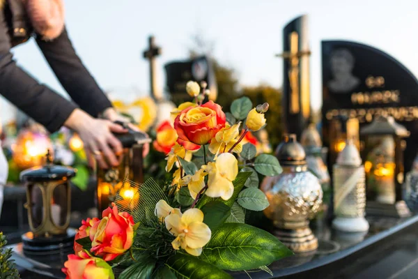 人工と本物の花と蝋燭の墓地の墓石の上に横たわる — ストック写真