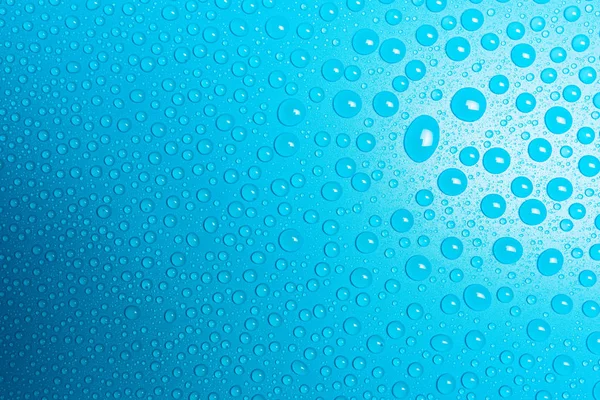Σταγονίδια Νερού Ένα Μπλε Ματ Φόντο Που Φωτίζεται Ένα Ευαίσθητο — Φωτογραφία Αρχείου