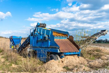Bulutlar ile arka plan mavi gökyüzünde, sahada mavi renk ayakta çakıl ve kum için eski, mobil ekran.
