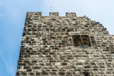 Beyaz bulutlarla mavi bir gökyüzüne karşı tarihi bir kulenin kalıntıları.