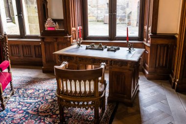 Bad Bentheim, Almanya - 9 Haziran 2019. 11. yüzyıl Bentheim kalesinin antik iç. Kale tamamen kumtaşı bloklardan inşa edilmiştir. Eski, antika ahşap masa.