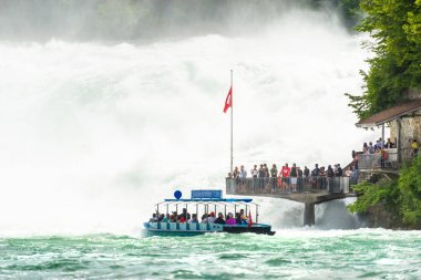 Neuhausen Rheinfall, İsviçre - 23 Temmuz 2019. İsviçre'de Neuhausen Rheinfall şehrinde Ren nehri üzerinde Şelale. Turistler altında bir acele şelale akar bakış noktasında duran.