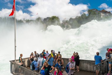 Neuhausen Rheinfall, İsviçre - 23 Temmuz 2019. İsviçre'de Neuhausen Rheinfall şehrinde Ren nehri üzerinde Şelale. Turistler altında bir acele şelale akar bakış noktasında duran.