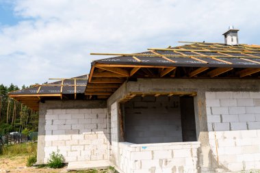 İnşaat aşamasında müstakil bir evde membran la kaplı çatı kirişleri, görünür çatı elemanları, battens, sayaç battens, kiriş.