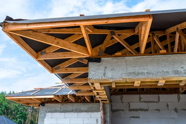 Roof trusses covered with a membrane on a detached house under construction, visible roof elements, battens, counter battens, rafters.