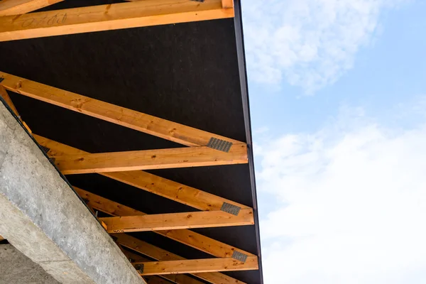 Roof trusses covered with a membrane on a detached house under construction, visible roof elements, battens, counter battens, rafters.