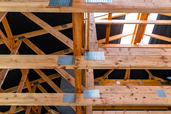 Roof trusses covered with a membrane on a detached house under construction, visible roof elements, battens, counter battens, rafters.