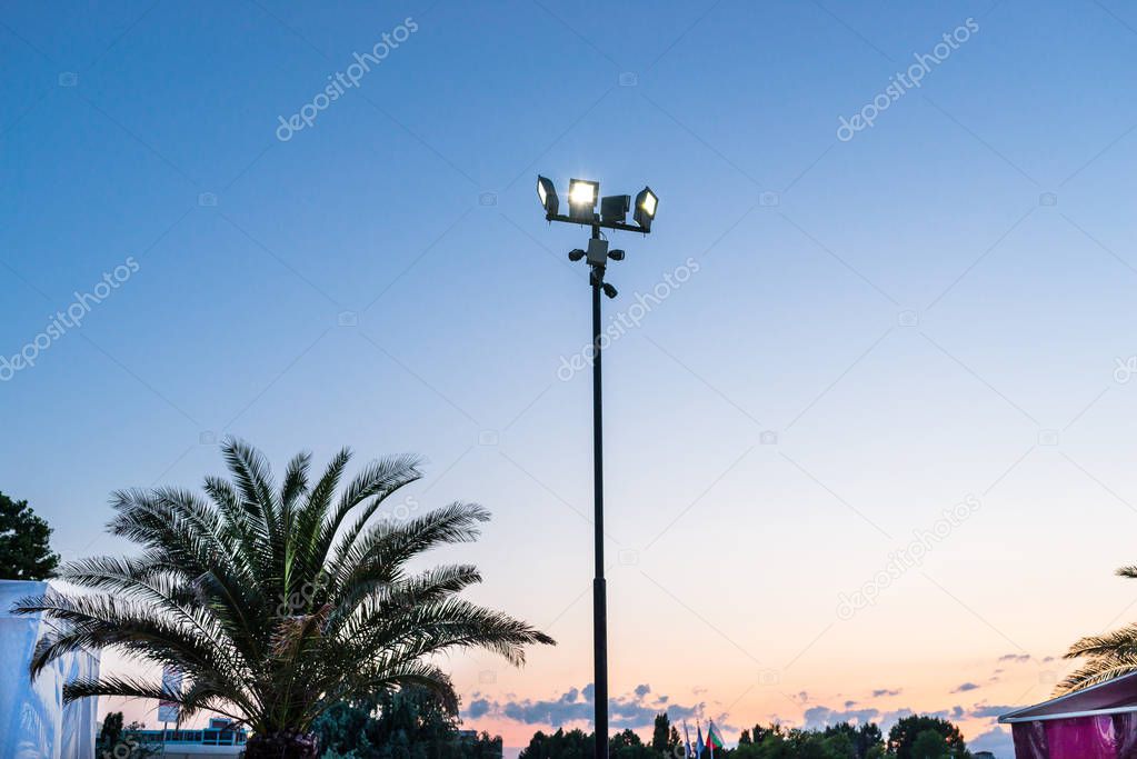Mast at the beach with four spotlights and four cameras attached.