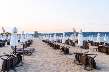Sunny Beach, Bulgaristan 13 Temmuz 2019. Bulgaristan'da Sunny Beach plajda şemsiye yanında yan yatan plaj şezlonglar, arka planda Karadeniz.