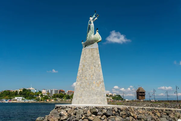 Nessebar, Bulgaristan 15 Temmuz 2019. Bulgaristan'da Nessebar'da aziz Nicholas heykeli. Nessebar'da popüler bir simge. Nessebar arazi ve ada parçası bağlayan geçit te bulunur. Arka planda eski bir yel değirmeni.