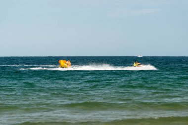 Sunny Beach, Bulgaristan 13 Temmuz 2019. Bulgaristan'da Sunny Beach kıyılarında Karadeniz'de bir motorbot tarafından çekilen insanlar ile şişme eğlence muz tekne.