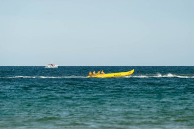 Sunny Beach, Bulgaristan 13 Temmuz 2019. Bulgaristan'da Sunny Beach kıyılarında Karadeniz'de bir motorbot tarafından çekilen insanlar ile şişme eğlence muz tekne.