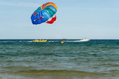 Sunny Beach, Bulgaristan 13 Temmuz 2019. Bir motorbot, Bulgaristan'ın Sunny Beach açıklarında Karadeniz'de iki turistle birlikte paraşüt çekiyor. Parasailing uygulayan turistler.