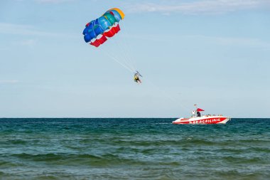 Sunny Beach, Bulgaristan 13 Temmuz 2019. Bir motorbot, Bulgaristan'ın Sunny Beach açıklarında Karadeniz'de iki turistle birlikte paraşüt çekiyor. Parasailing uygulayan turistler.