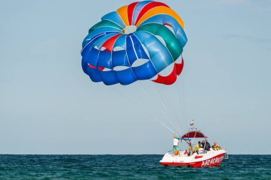 Sunny Beach, Bulgaristan 13 Temmuz 2019. Bir motorbot, Bulgaristan'ın Sunny Beach açıklarında Karadeniz'de iki turistle birlikte paraşüt çekiyor. Parasailing uygulayan turistler.