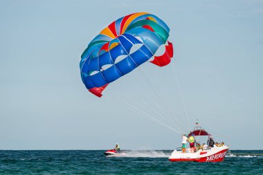Sunny Beach, Bulgaristan 13 Temmuz 2019. Bir motorbot, Bulgaristan'ın Sunny Beach açıklarında Karadeniz'de iki turistle birlikte paraşüt çekiyor. Parasailing uygulayan turistler.