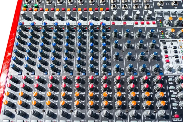 Close up photo of a professional sound mixer with many adjustments, knob switches and buttons of audio mixer control panel.