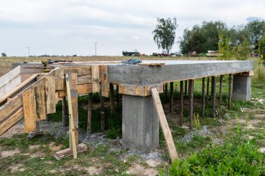 Beton direkleri üzerinde dikdörtgen şeklinde betonarme levha. Görünür kalıp ve bina yumrukları.
