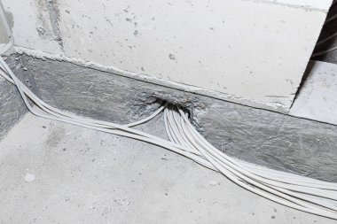Yeni yapılmış bir evin zeminine elektrik kabloları döşemiş. Evin temellerinden geçen kablolar..