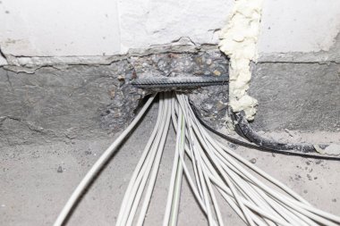 Yeni yapılmış bir evin zeminine elektrik kabloları döşemiş. Evin temellerinden geçen kablolar..