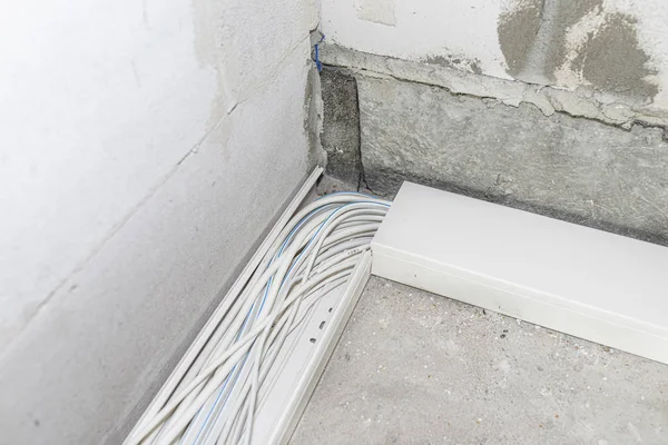 Layed installation of electric cables on the floor in a newly built house. Cables lying in plastic trays.