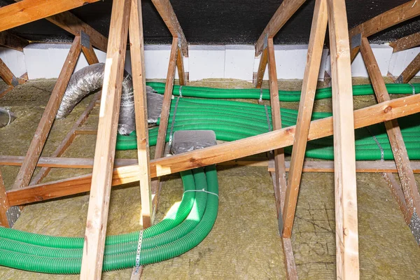 家用能源回收通风 可见集热器和绿色柔性管接头 用可见岩棉布置在屋顶桁架上 — 图库照片