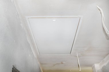 Tavan arasına kapalı bir giriş. Evin tavanında katlanmış bir merdiven var..