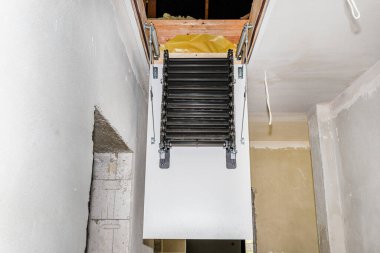Çatı katına çıkan metal merdivenler, açık bir kapak ve yerleşik merdivenler, modern görünüş..