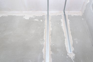 LED ışıklandırma için alüminyum profil yeni inşa edilmiş bir evin tavanına beton kireç alçıyla döşenmiş bir duvara yerleştirilmiş..