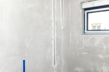 LED ışıklandırma için alüminyum profil yeni inşa edilmiş bir evin tavanına beton kireç alçıyla döşenmiş bir duvara yerleştirilmiş..