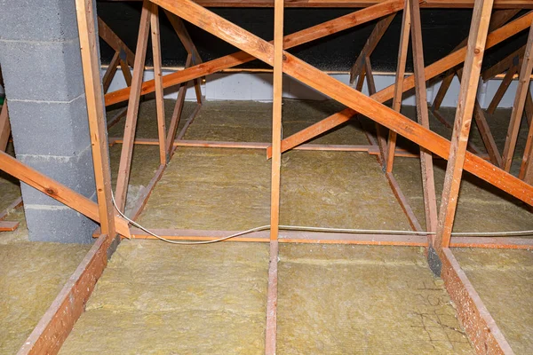 Ceiling and attic floor insulation made of rock wool between the trusses, visible system chimney.